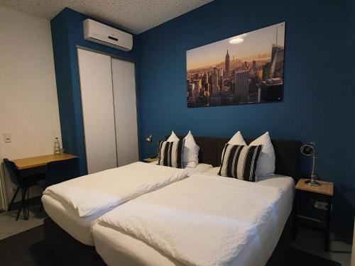 金策尔Argenta Living 131的两张位于酒店客房的床,拥有蓝色的墙壁