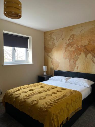 布莱克浦Cheerful 3 Bedroom Town House With Hot Tub的卧室配有一张大床,墙上挂有地图
