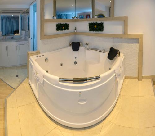 万卡约Hotel Huaytapallana suites的浴室内设有大型白色浴缸。