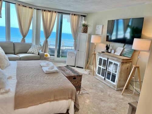 代托纳海滩Beach Oasis 704 Lovely Daytona ocean front for 5 sleeps up to 12的客厅配有床和平面电视