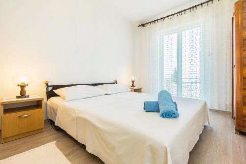 斯姆里卡Apartments with a parking space Smrika, Kraljevica - 5508的一间卧室配有一张带蓝色毛巾的床