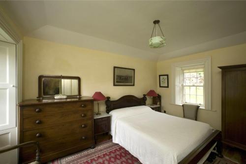 卡波昆Salterbridge Gatelodge的一间卧室配有一张床、梳妆台和镜子