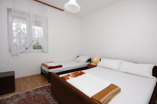 普纳特Apartment Punat 5350b的一间卧室设有两张床和窗户。