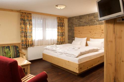 上施陶芬阿尔高克劳特兰酒店的一间卧室配有一张床,楼上配有电视
