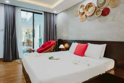 会安PHỐ CHỢ ĐÊM Villa的卧室配有带红色枕头的大型白色床