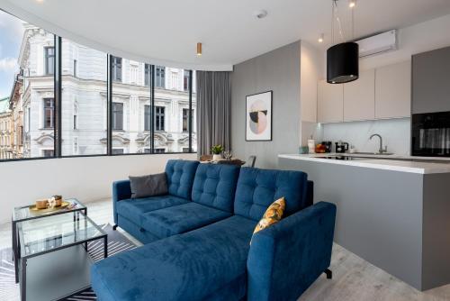 别尔斯克-比亚拉Apartament Prestige Centrum的一间带蓝色沙发的客厅和一间厨房