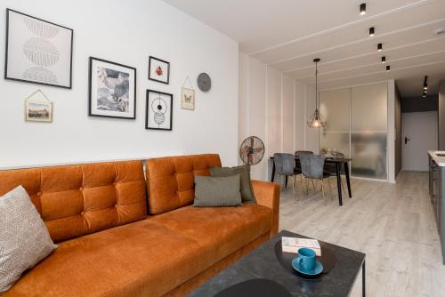 别尔斯克-比亚拉Apartamenty Prestige Centrum的带沙发的客厅和用餐室