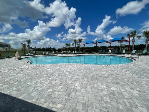 海恩斯城Cozy suites 4 less的一座棕榈树和蓝天的大型游泳池