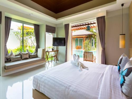 蔻立奥勒森林度假酒店的卧室设有白色的床和大窗户