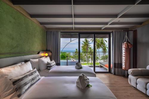 拉迈Thai Fight Hotel的酒店客房设有两张床和一个阳台。