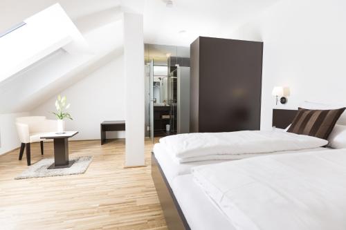 维也纳附近格拉斯多夫杰霍林格民宿的白色卧室配有床和桌子