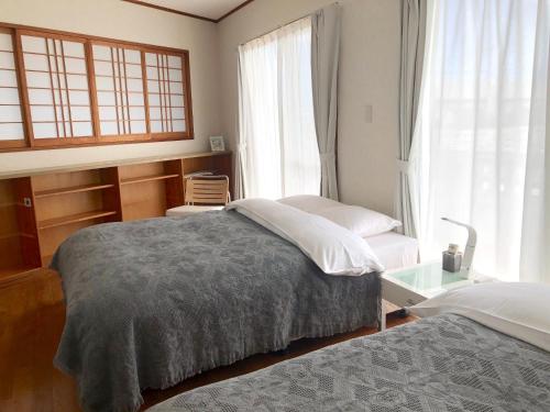 石垣岛Ishigaki - House / Vacation STAY 11269的一间卧室设有两张床和窗户。
