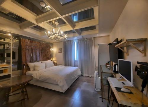 釜山SongJeong Lesign Hotel的一间卧室配有一张床和一张带电脑的书桌