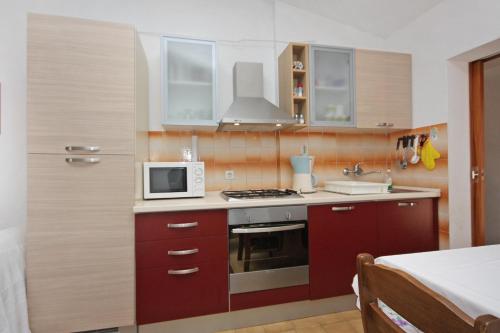 苏佩塔尔Apartments with a parking space Supetar, Brac - 5653的带微波炉和炉灶的小厨房