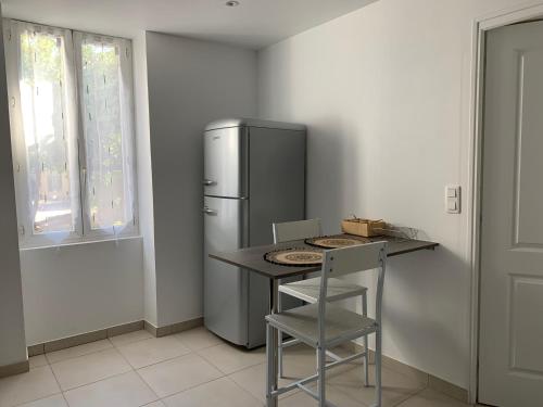 耶尔L'Almanarre的厨房配有冰箱和桌椅