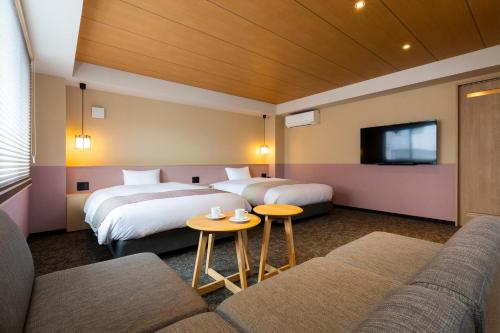京都Rinn Gion Yasaka的酒店客房,设有两张床和一张沙发