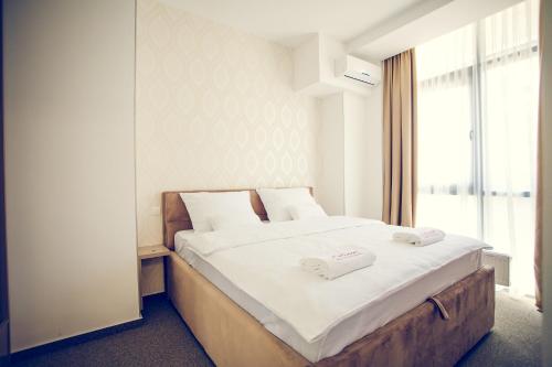 巴尼亚卢卡Apartmani SL Luxury的一间卧室配有一张大床和两条毛巾