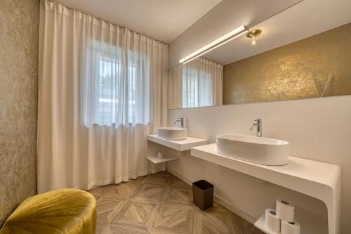 拉纳goldfinger + suites的浴室设有2个水槽和镜子