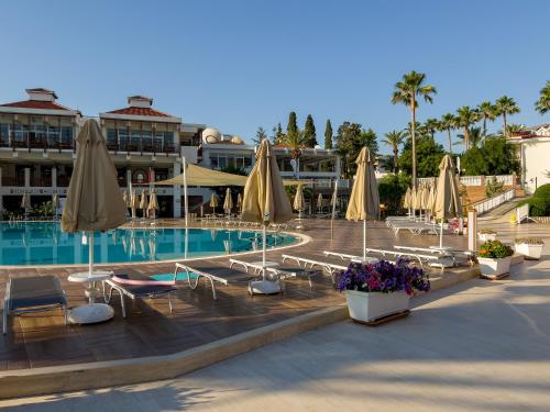 凯麦尔AQI Hydros Club的度假村内带椅子和遮阳伞的游泳池