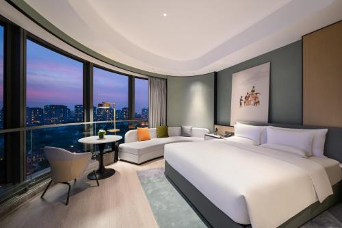 上海上海万源诺富特酒店的卧室设有白色的床和大窗户