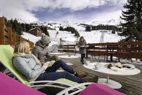 阿克1800Belambra Clubs Arc 1800 - Hôtel Du Golf的一群坐在滑雪场桌子上的人