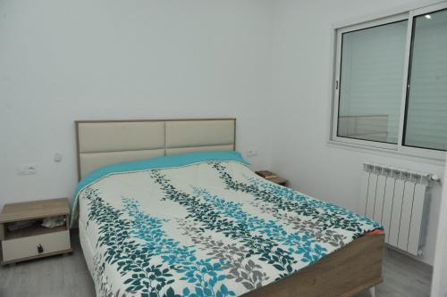 哈曼苏斯SOUSSE BEACH的一间卧室配有一张带蓝色和白色棉被的床