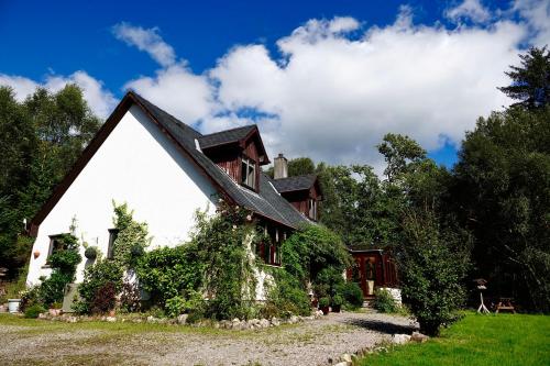 威廉堡Tarmachan Cottage - West Highland Getaway的常春藤生长在房子的一侧