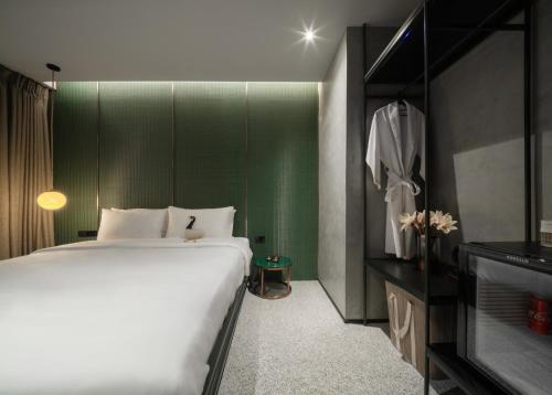曼谷Goose Living的一间卧室设有一张大床和绿色的墙壁