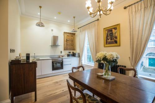 伦敦德里Bishop's Gate Hotel的厨房以及带木桌的用餐室。