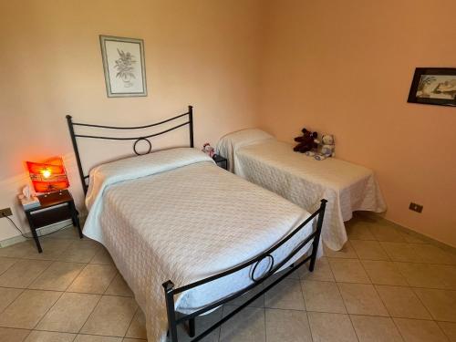 VeroliLA CASA IN COLLINA的一间带两张床的卧室,铺有瓷砖地板。
