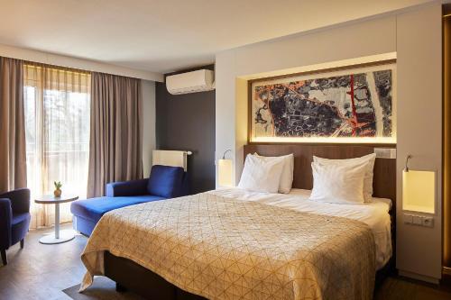 蒂尔堡杜博纳尔旅馆的酒店客房,配有一张床和一张蓝色椅子