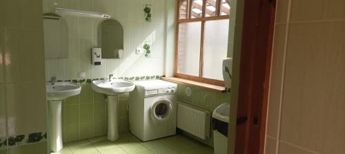 Ķegums斯聂德斯野营地的一间带两个盥洗盆和洗衣机的浴室