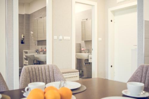 巴尼亚卢卡Apartmani SL Luxury的一间带桌子和两个水槽的用餐室