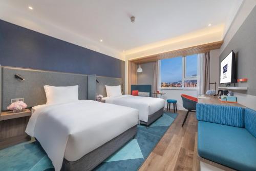 上海上海嘉定城中智选假日酒店的酒店客房,设有两张床和一张沙发