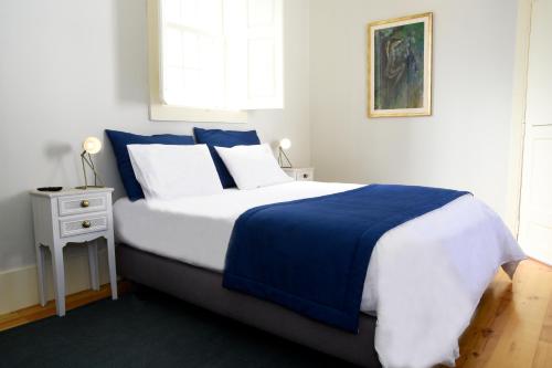 MurtosaCasa Galricho的卧室配有蓝色和白色的床和窗户。