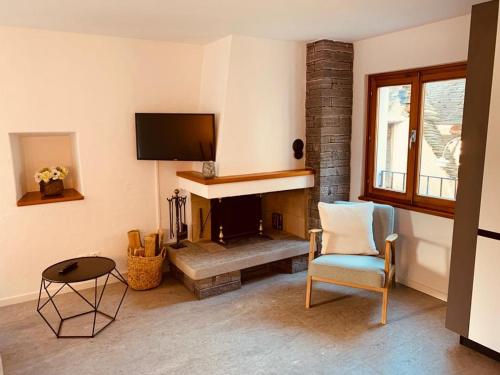 LionzaCasa Mille Sassi的客厅设有壁炉、椅子和电视
