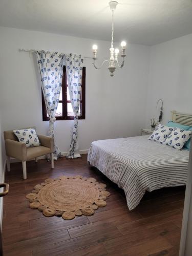 卡勒达德福斯特Villa La Charlatana的卧室配有床、椅子和窗户。