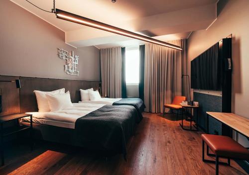赫尔辛基Hotel Mestari的酒店客房设有一张大床和一张书桌。