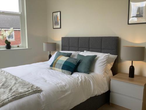 莫珀斯Modern 3 bed house in the heart of Morpeth town.的一间卧室配有带白色床单和枕头的床。
