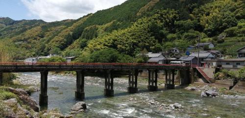 Inoそらやまゲストハウス Sorayama guesthouse的穿越河上的桥梁的火车