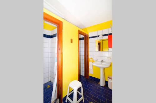普拉卡利特索罗Summit Zero Hostel的黄色的浴室设有水槽和凳子