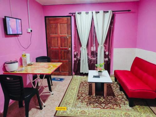 加央Pink Homestay D'Perlis的客厅配有红色的沙发和桌子