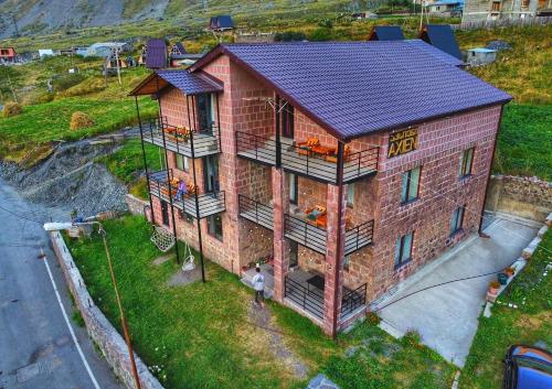 卡兹贝吉Hotel Axien Kazbegi的享有带太阳能屋顶的房子的顶部景色