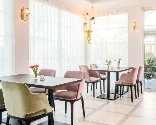 克拉科夫Merci Boutique Hotel的带窗户的客房内配有2张桌子和椅子