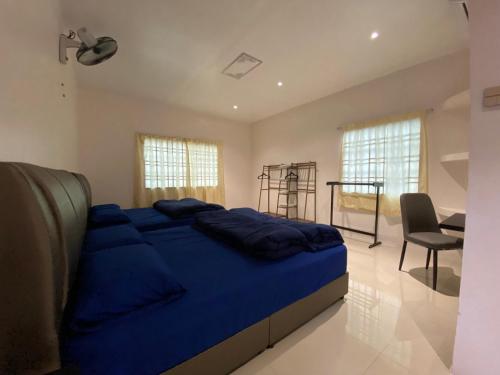 丰盛港Beautiful River Homestay & Room Mersing的一间卧室配有一张蓝色的大床和一张书桌