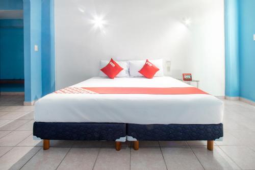 José CardelOYO Hotel Estacion,José Cardel,Parque Central Revolución的一间卧室配有一张带红色枕头的大床