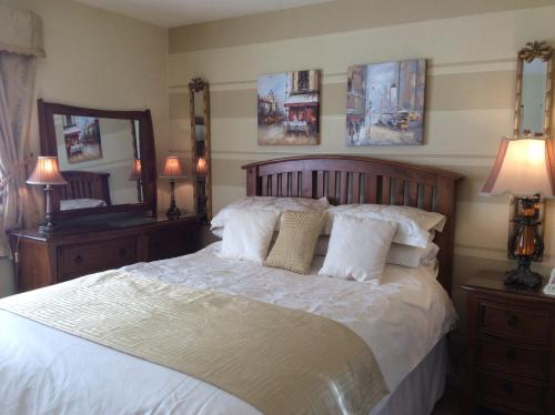 Randalstown西勒根旅舍的卧室配有一张带白色床单和枕头的大床。