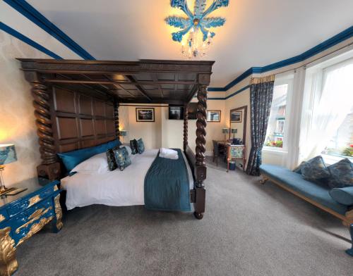 凯西克Allerdale Guest House的一间卧室配有一张大天蓬床和一张沙发