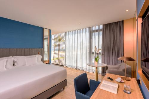 丹吉尔Barceló Tanger的酒店客房配有一张床铺、一张桌子和一张书桌。