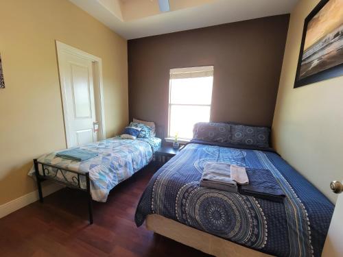 麦卡伦Modern, Private, Smart 4 BR Condo in Desirable Location in McAllen with Pool!的一间卧室设有两张床和窗户。